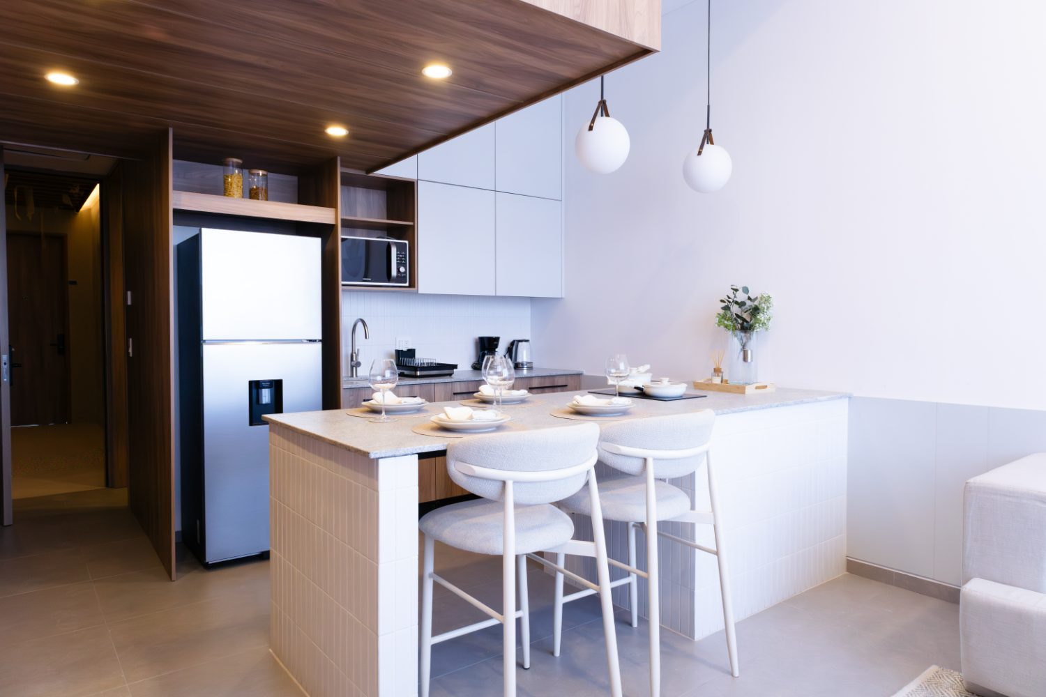 Cocina equipada con barra-comedor y muro de madera, modelo Gala